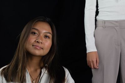 Portrait of a beautiful young woman over black background