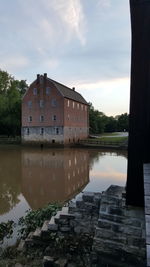 Reflection of building in lake against sky