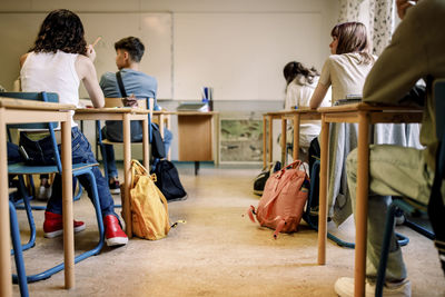 Multiracial group of students sitting at desk in classroom