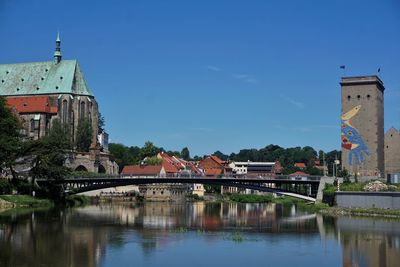 Arch bridge over river against buildings