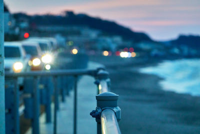 Close-up of illuminated car front  light against sky during sunrise