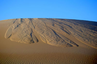 Scenic view of desert against clear blue sky