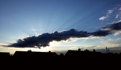 Silhouette buildings against sky at sunset