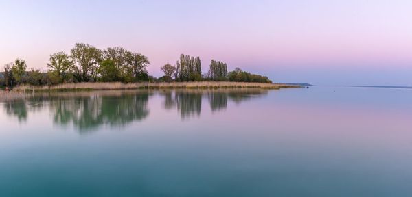 Scenic view of lake against clear sky during sunset