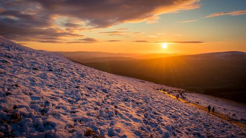 Scenic view of snowcapped mountains against sky during sunset