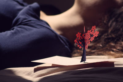 Close-up of decoration by woman lying on bed at home