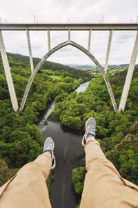 Low section of man on bridge against plants