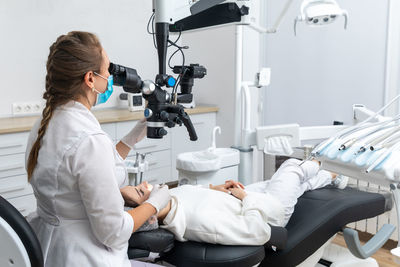 Rear view of doctor operating patient in clinic