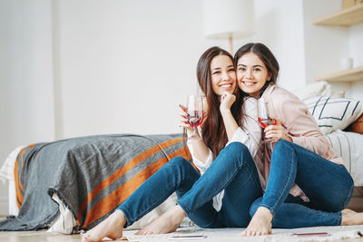 Portrait of happy friends enjoying wine at home