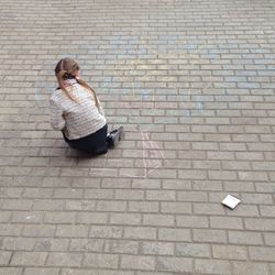 High angle view of woman on cobblestone street