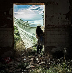 Full length of woman standing by railing against sky