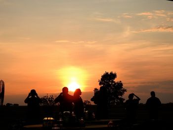 Silhouette people against sky during sunset