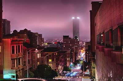 Illuminated cityscape against sky at night