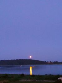 Scenic view of lake against clear sky at night