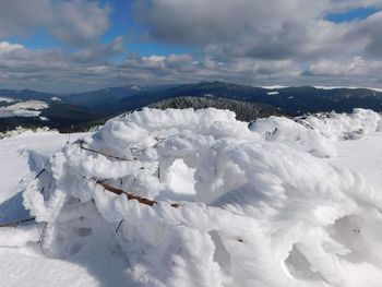 Snow covered mountain against cloudy sky