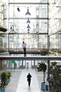 Young businessman standing in lobby at office atrium