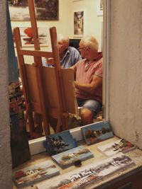 Senior men painting on easel at home