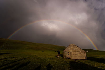 Rainbow over landscape against sky