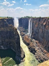 Scenic view of waterfall against sky