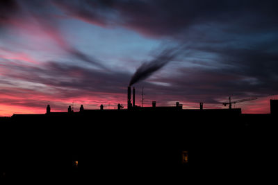 Silhouette city against sky during sunset