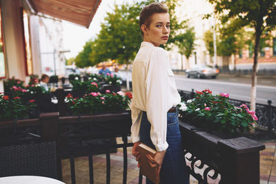 Woman standing by potted plants