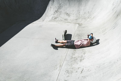 Male athlete relaxing at skateboard park on sunny day