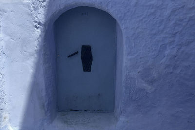 Close-up of blue door and white wall