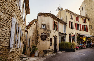 Footpath amidst buildings in town against sky