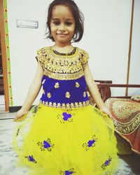 Portrait of smiling girl standing against wall