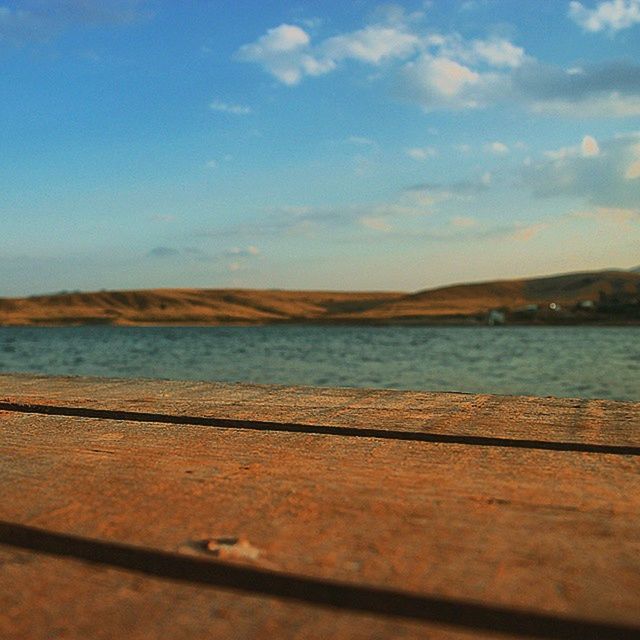 water, sky, tranquil scene, tranquility, wood - material, lake, scenics, mountain, nature, pier, beauty in nature, sea, day, outdoors, wooden, idyllic, surface level, railing, no people, wood