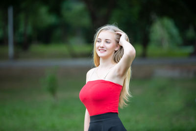 Beautiful young woman standing against blurred background
