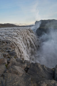 Scenic view of waterfall against sky