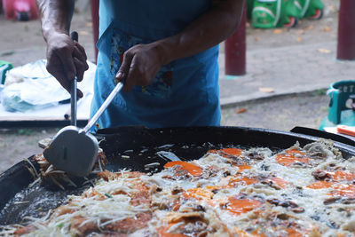 Midsection of man preparing food at market