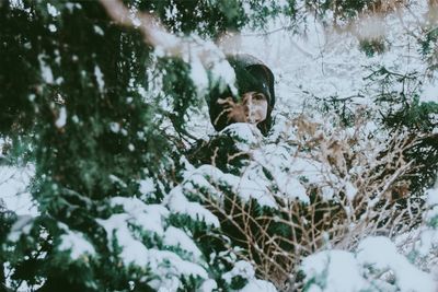 Portrait of woman on snow covered trees during winter