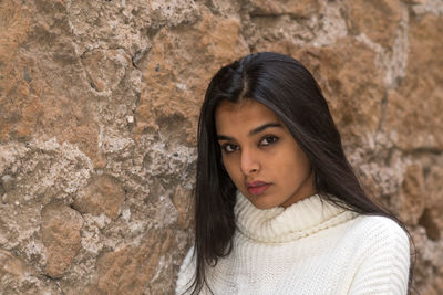 Portrait of a beautiful woman against wall