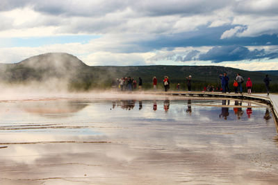 Group of people in water against sky