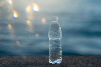 A bottle of clean drinking water and a sea with beautiful sunlight