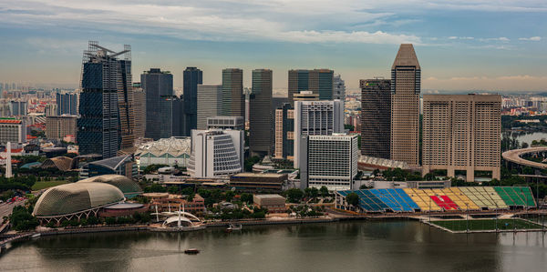 High angle view of buildings by river in city against sky