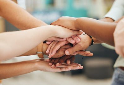 Midsection of people stacking hands