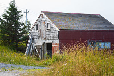 Old abandoned house on field against sky