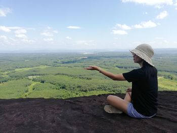 Man sitting on rock looking at view