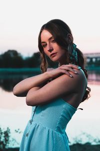 Portrait of beautiful woman standing against sky