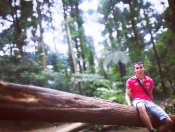 Low angle portrait of smiling man in forest