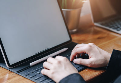 Midsection of man using laptop on table