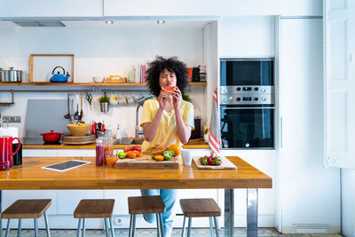 Woman holding fruit standing in kitchen