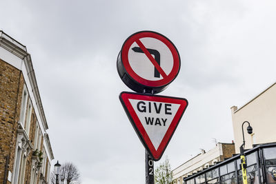 Give way traffic sign on urban street corner guiding drivers for safe road navigation