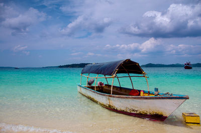 Boat moored on sea against sky