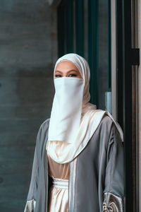 Portrait of smiling veiled woman with white niqab and hijab looking at the camera