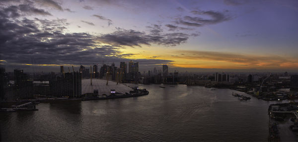 Scenic view of sea and buildings against sky during sunset