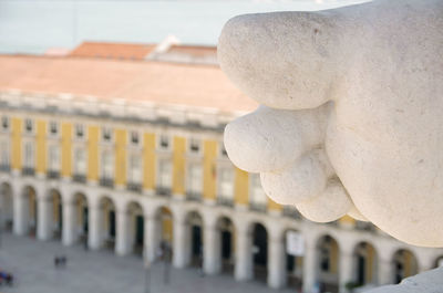 Cropped hand of man standing against building